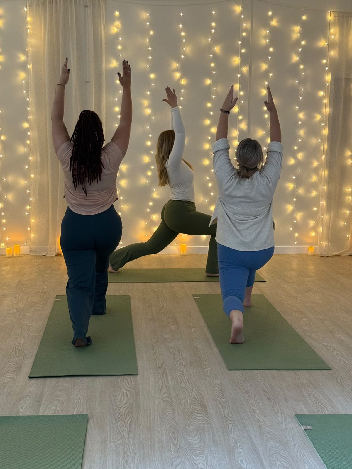 A small yoga class at RESET Ruthin moving together on green mats