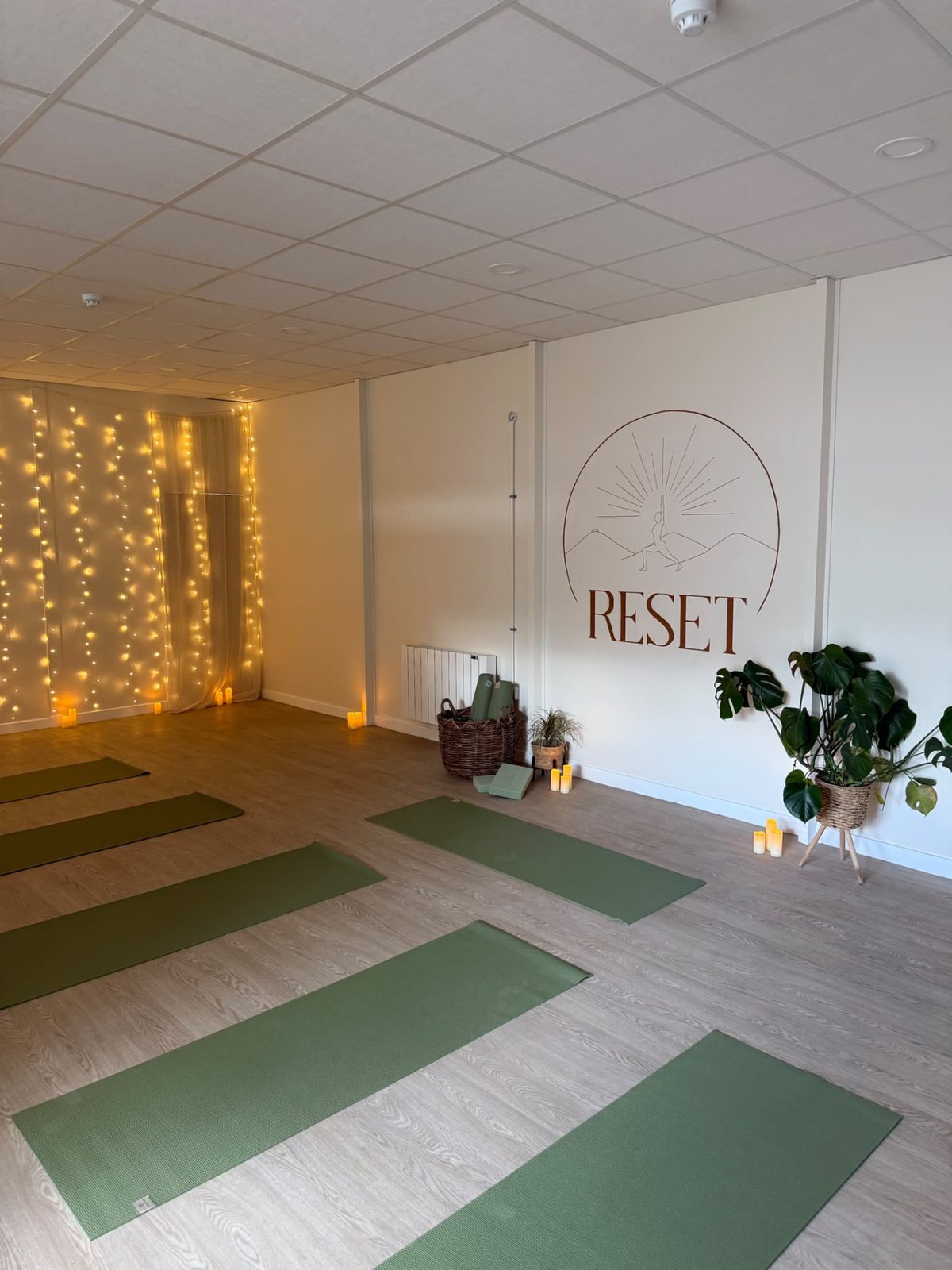 The RESET Ruthin studio with its wall logo, green mats and warm lights